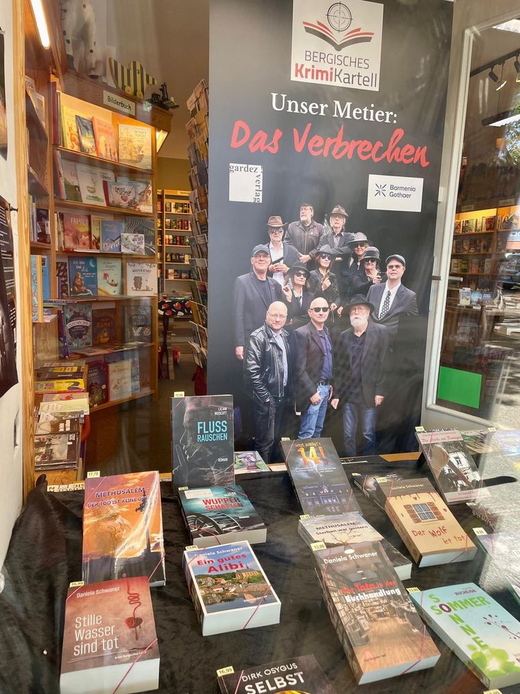 Das Bergische Krimikartell: Ein Rollup und einige Bücher in der Auslage.