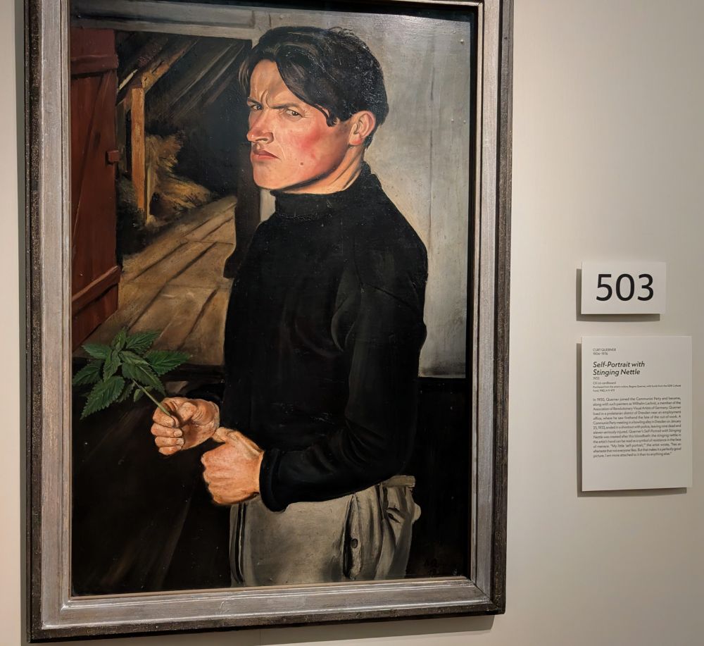 Self-Portrait with Stinging Nettle by Curt Querner (1933)

A 1933 oil painting of Curt Querner standing in a dim attic-like space. He wears a black turtleneck and beige trousers, holding a sprig of stinging nettle in one hand. His expression is tense and defiant, with furrowed brows and a piercing stare. The stinging nettle, a plant known for its painful sting, symbolizes Querner’s resistance to rising fascism and aligns with his Communist beliefs. The cramped, shadowed setting and stark lighting amplify the mood of political urgency and personal resolve during the Nazi rise to power.

