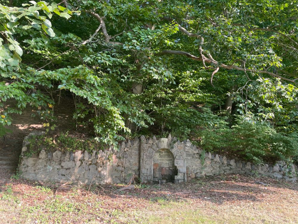 A photo of the stone spring today, no longer running and in disrepair.