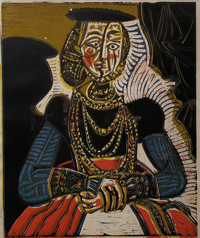 Abstract painting by Pablo Picasso of high class woman with ornate dress and jewels, against black, gold and white background. 