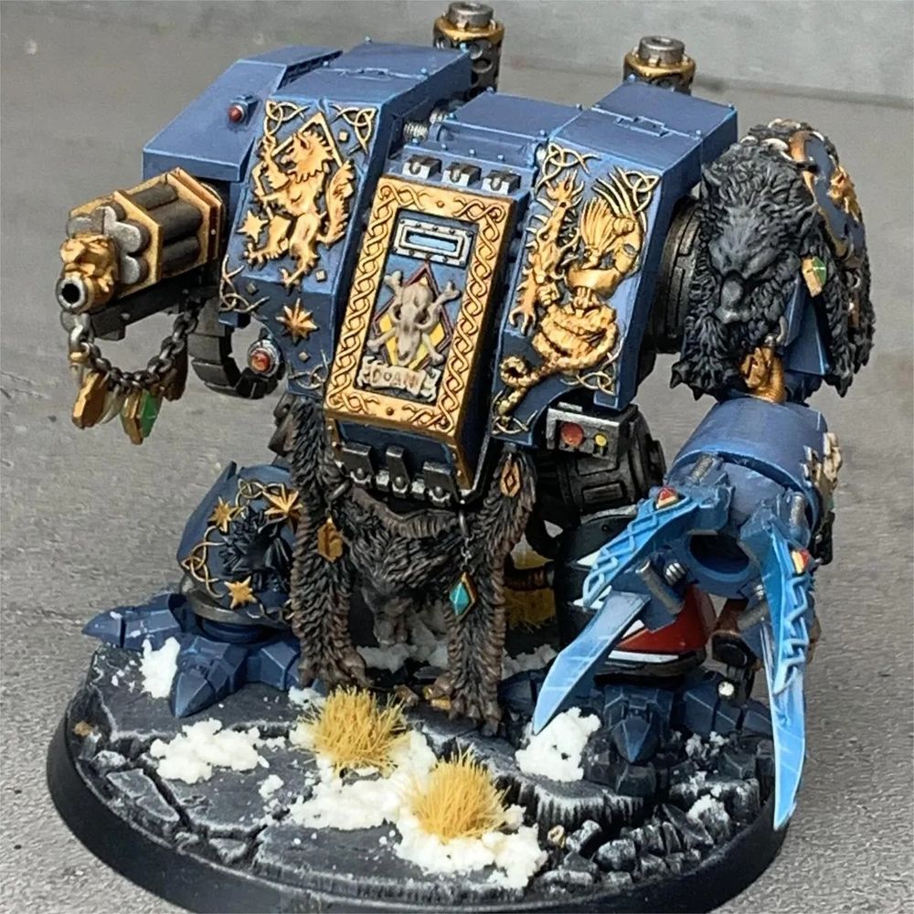 A light blue space marine dreadnought covered in gold viking iconography and furs