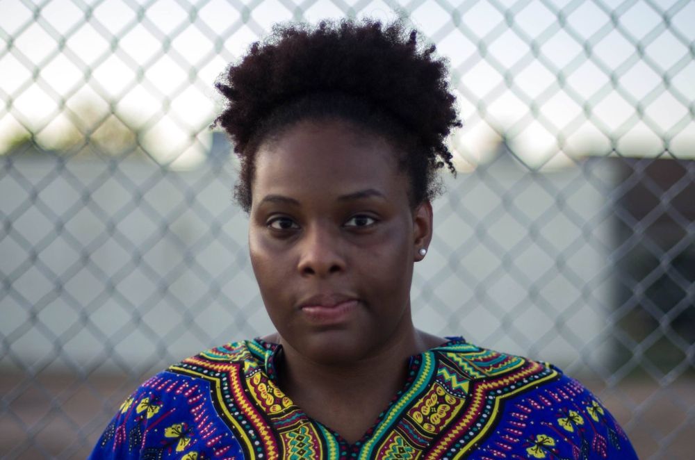 portrait of Mirissa Tucker; she is wearing a loose, colorful, patterned shirt; her hair is up; her expression: maybe: earnest, wistful, and determined