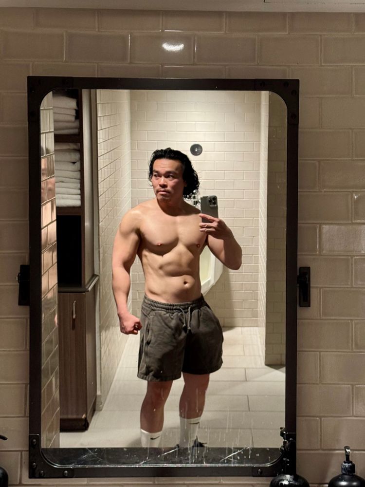 Me snapping a photo of myself in the dirty gym mirror with what looks like toothpaste stains. 