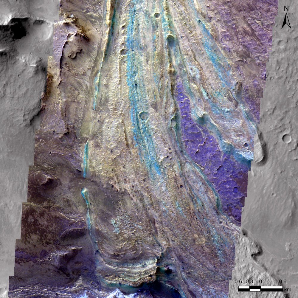 An image of the surface of Mars, where a landslide deposit runs top to bottom. Streaks of colours (blues, cyans) stretch through the landslide.