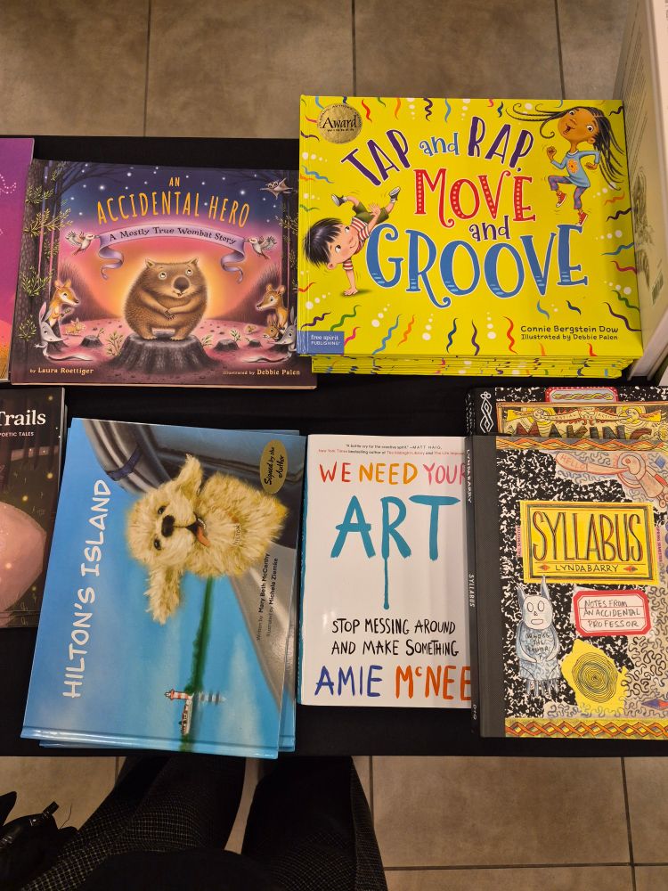 A group of stacks of books on a table. 