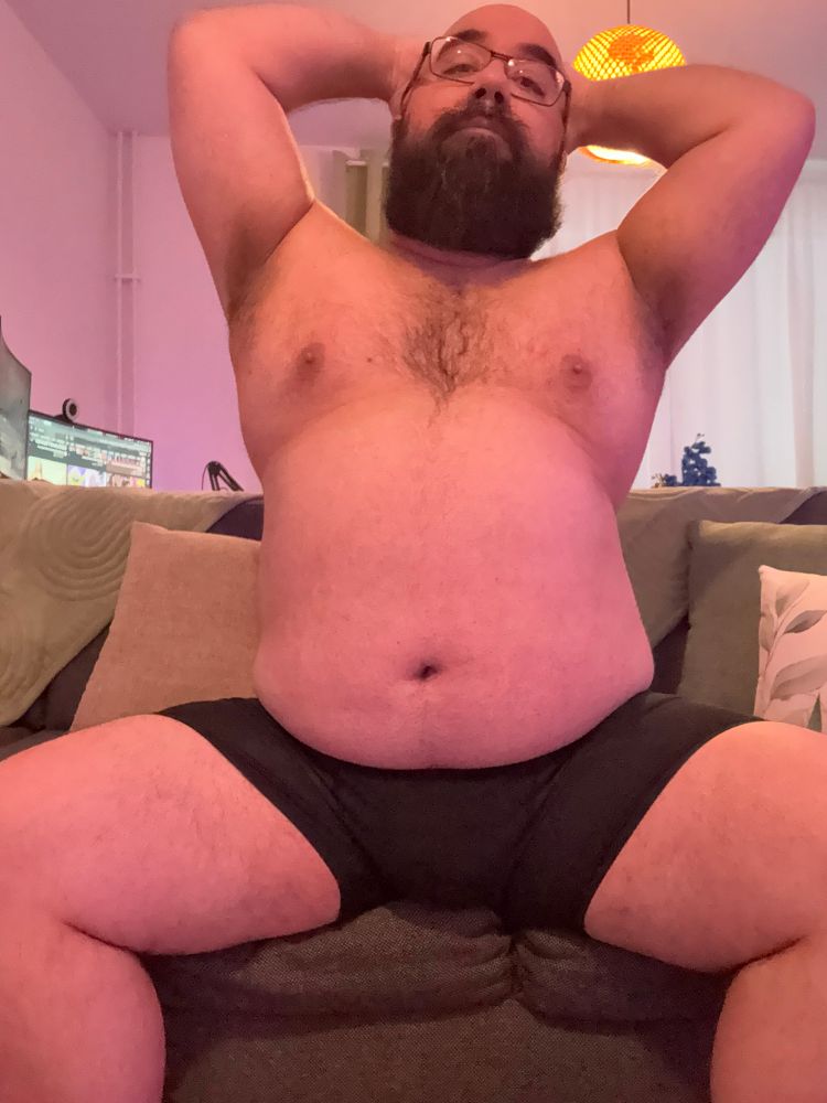 Sitting on my couch with my legs splayed, wearing black boxerbriefs. Arms behind my head to show pits.