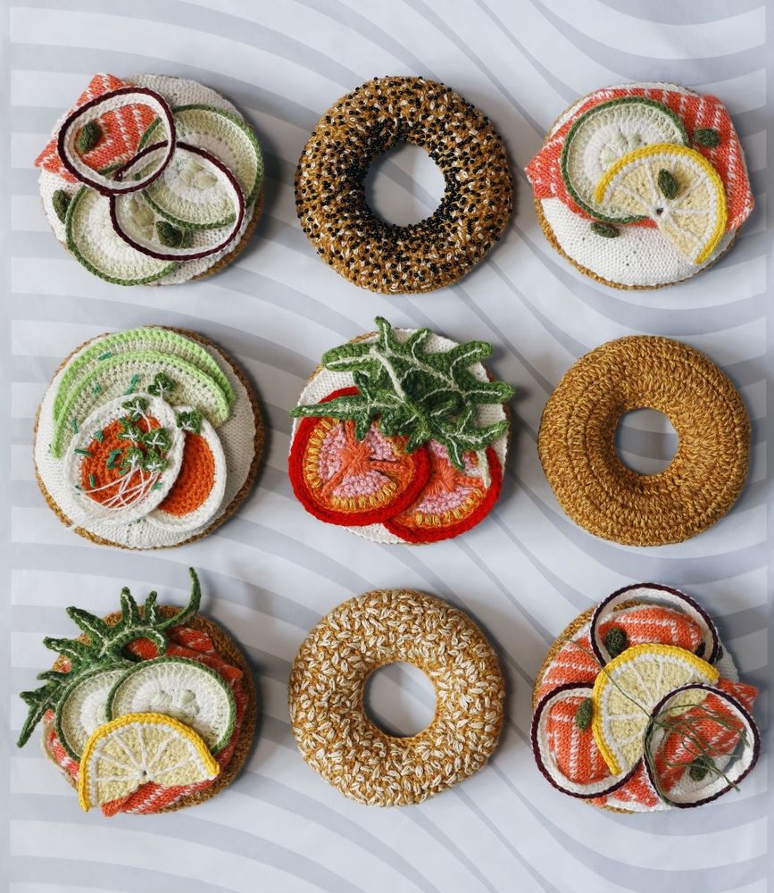 Photo of nine textile art creations made to look like bagels with various toppings such as egg and salmon