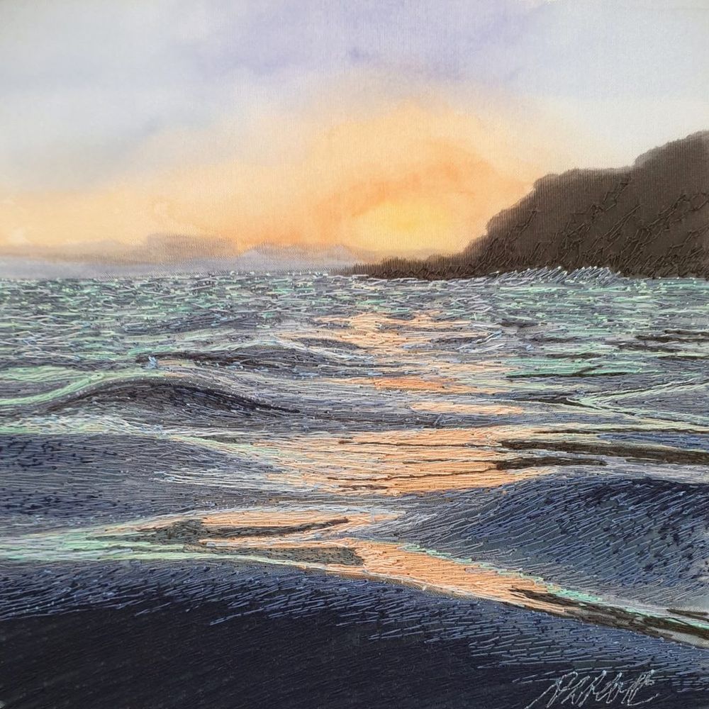 Pictorial textile artwork featuring a seascape with gentle waves and rippled water under a golden setting sun with a dark rocky cliff to the right in silhouette 