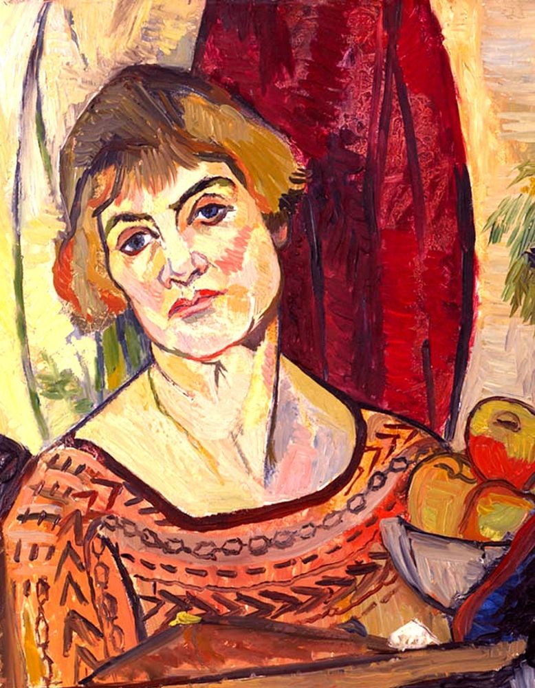 Portrait of a white woman head and shoulders looking outwards with head tilted, with short red hair and wearing a low cut top with patterns