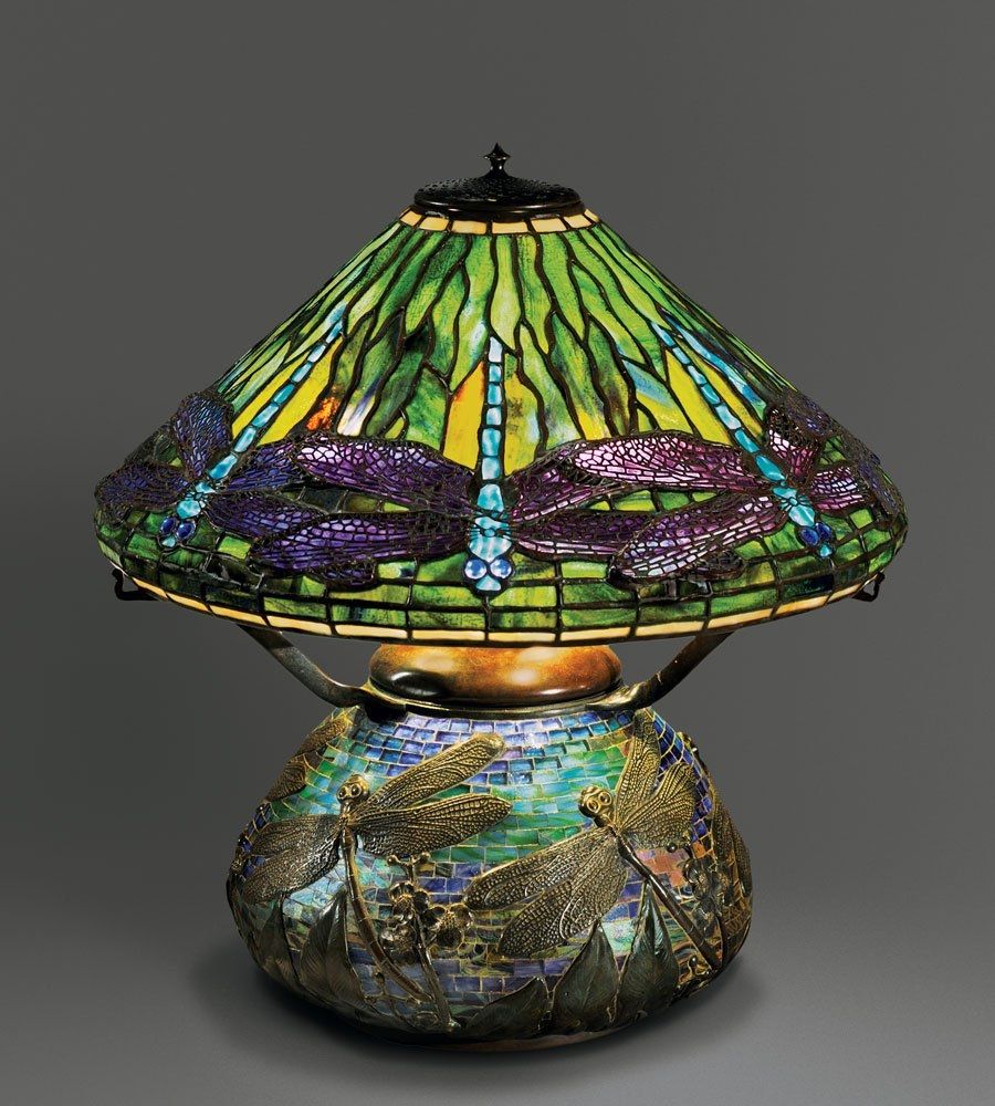 Photo featuring a lamp with stained glass shade decorated with dragon fly motifs in purple and green