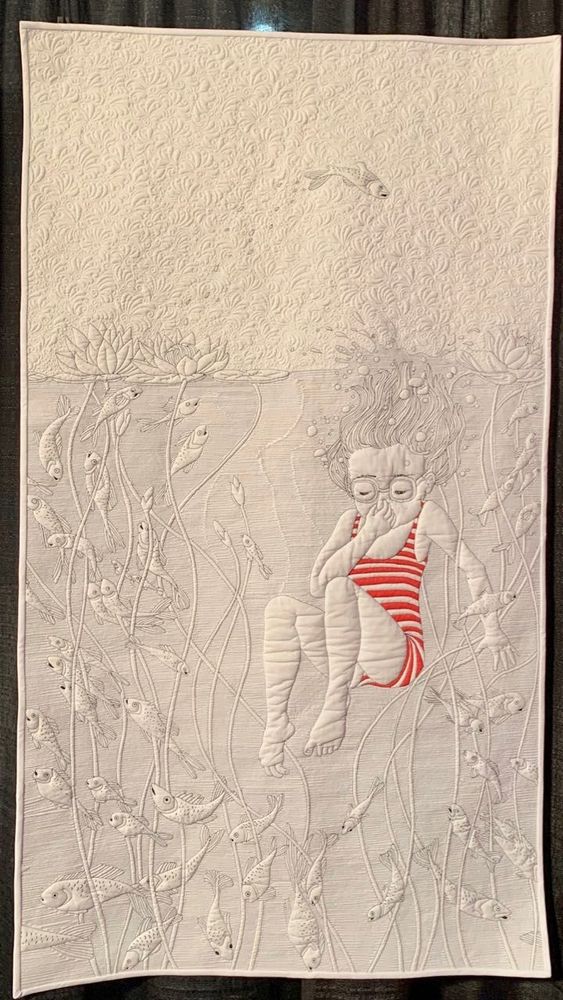 White quilt with pictorial detail of a girl juming into water holding her nose and wearing a striped bathing costume