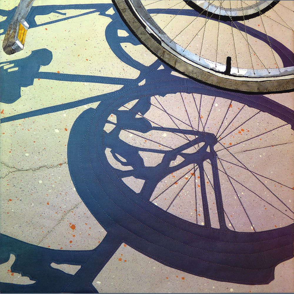 Textile artist with image of a section of a bicycle wheel and the shadow it makes on the ground