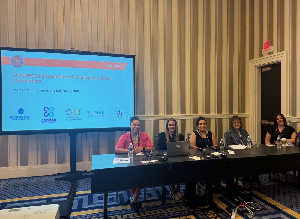 CHDI and our partners from Connecting to Care seated at a long table in front of the workshop sharing lessons learned from 10 years of Connecting to Care in CT