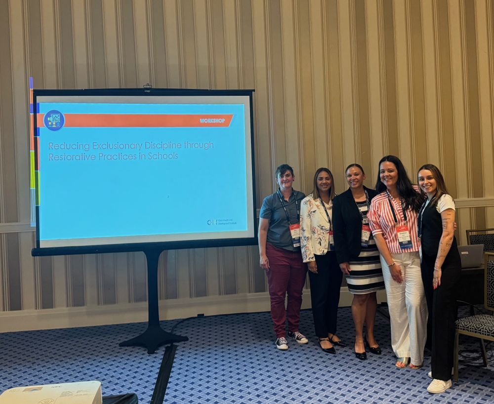 CHDI staff with partners standing together at the front of the Restorative Practices workshop