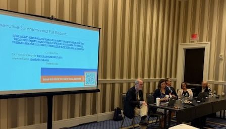 Panelists from CHDI, CT DCF, and Case Western Reserve University seated at a table beside a projector screen in this morning's Institute