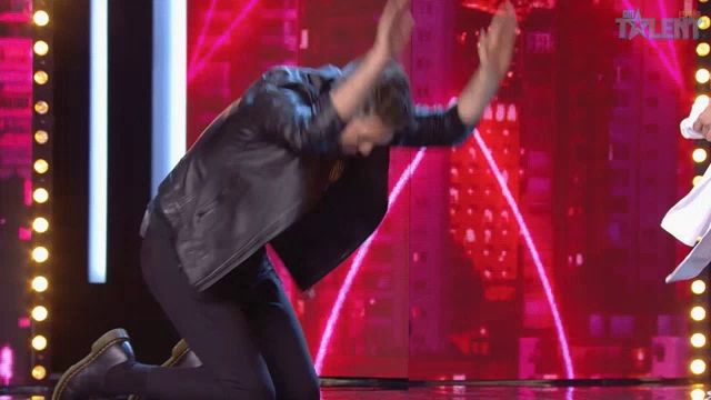 a man kneeling down on a stage with the word talent on the screen