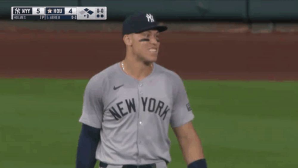 a man in a ny yankees jersey holds his fist up