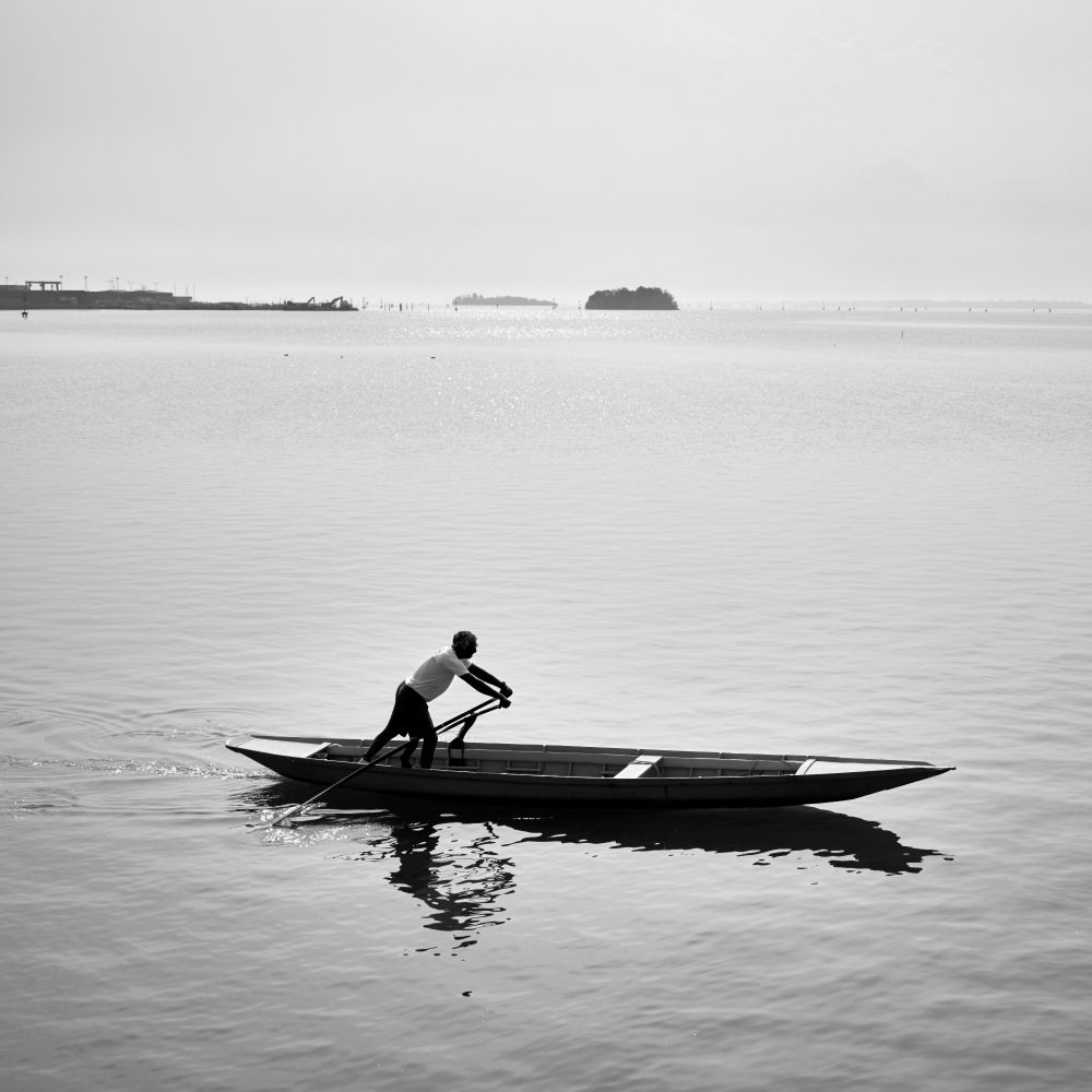 Monochrome photograph of rower on Venice Lagoon, Italy