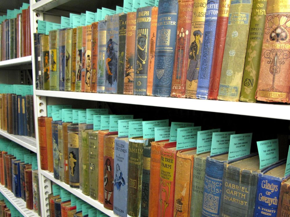 Shelves of books in the Chris Brooks Collection. The books in this photograph were written for children and young adults in the 19th and early 20th century, and many of them have colourful and illustrated bindings.