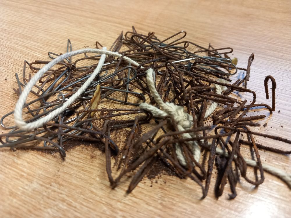 Pile of rusty paperclips and other rusty fasteners (plus a piece of string!) on a desk.