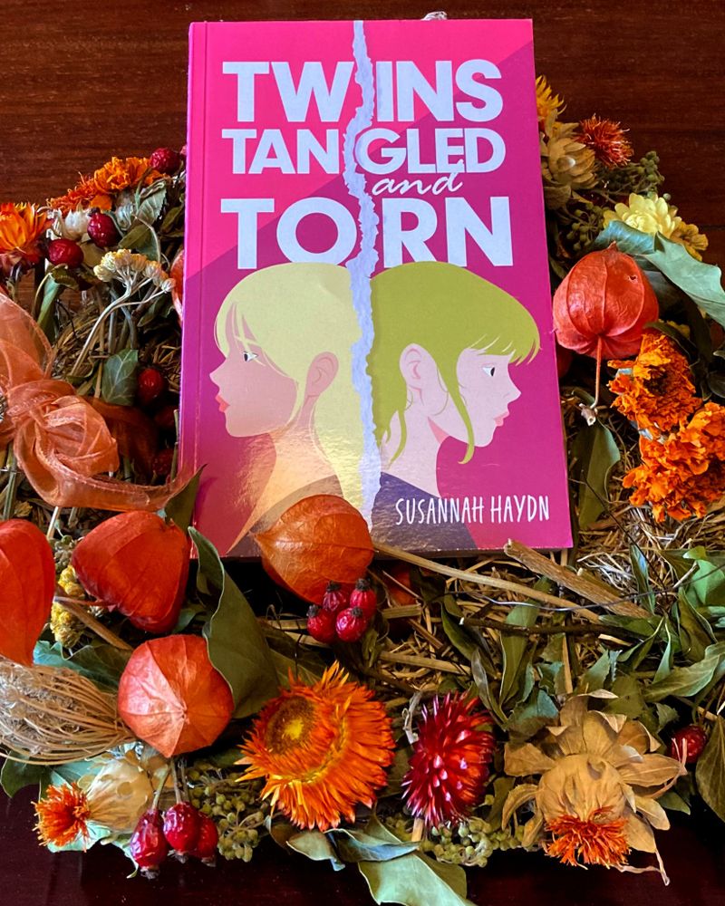 Photo of a copy of Twins, Tangled and Torn on an autumn wreath.