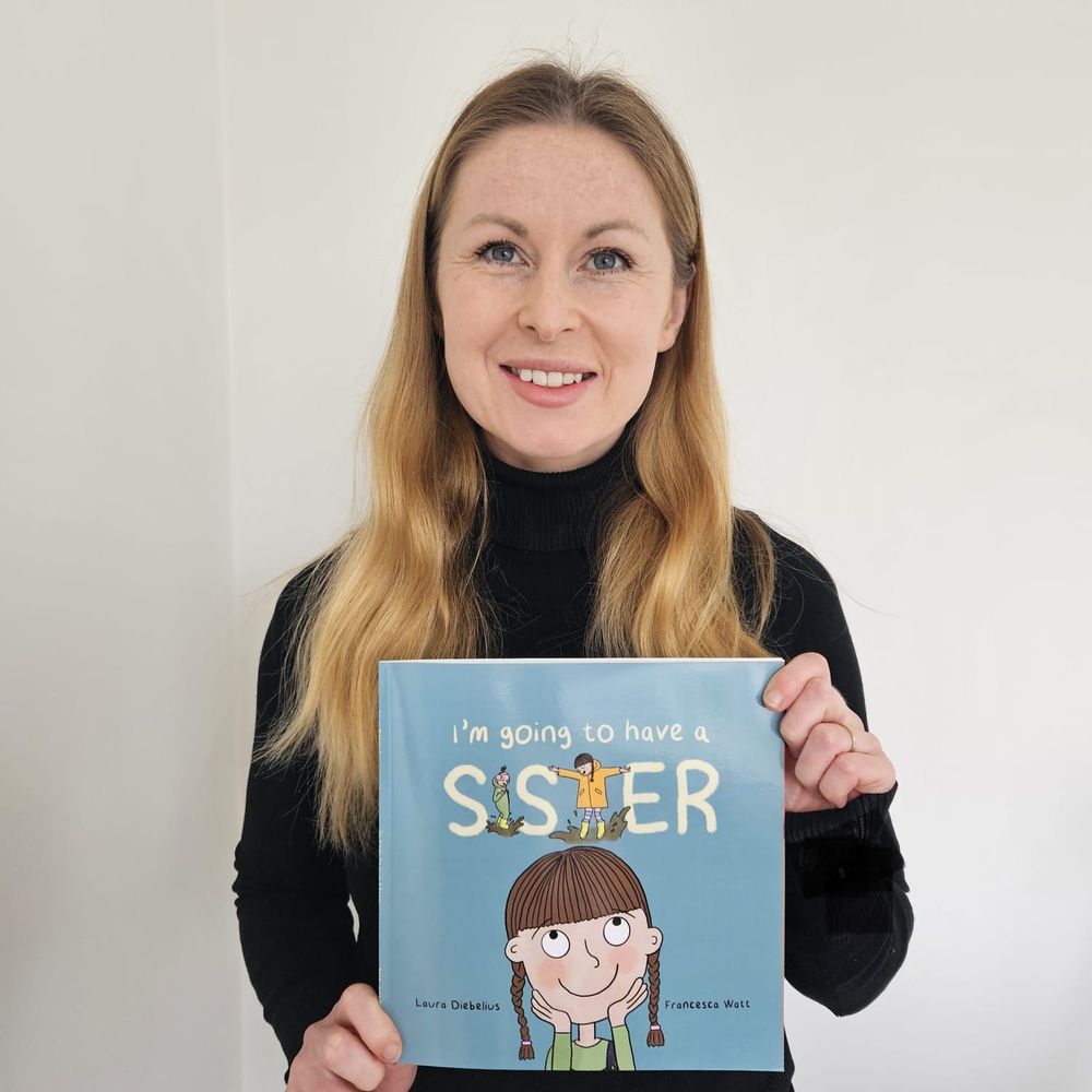 Photo of Laura Diebelius with a copy of I'm Going to Have a Sister.