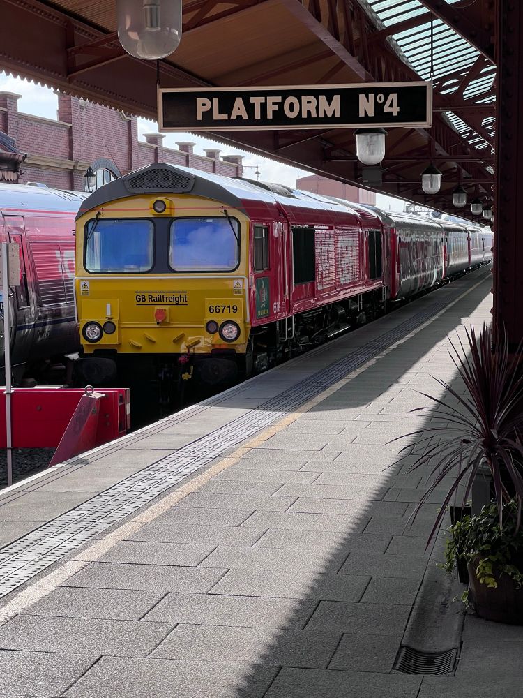 Image showing class 66 freight loco in pink colour with carriages behind that form the new mobile railway muses in for the 200th anniversary of the railway. 