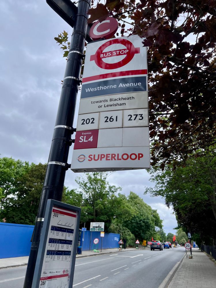 Picture of bus stop flag with new red SL4 tile showing route added and Supeoop banner below