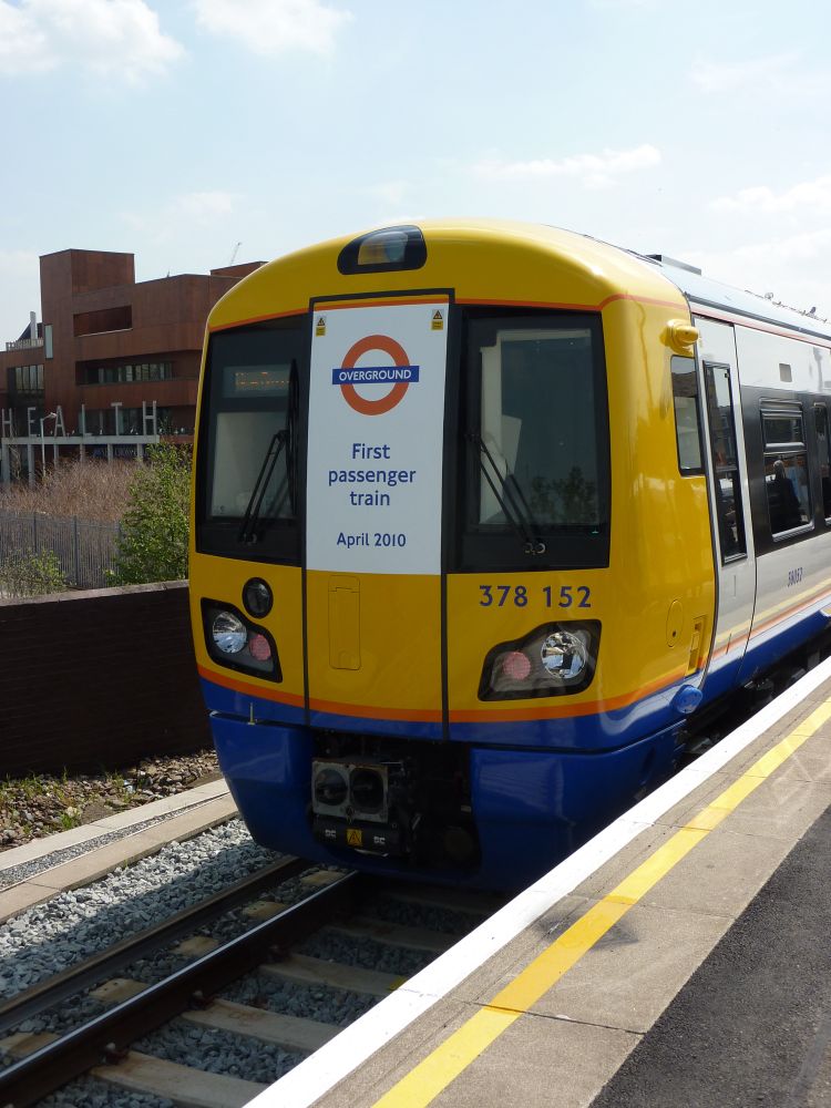 Picture of a Class 378 train at New Cross taken in April 2010 on opening day. The train has “first passenger train” in a sign mounted on the front 