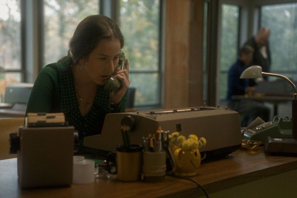 Alana Haim hablando por teléfono en una oficina.