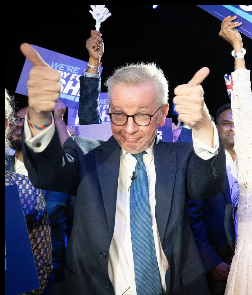 Michael Gove giving two thumbs up, but weirdly, because he's a fucking grotesque freak.