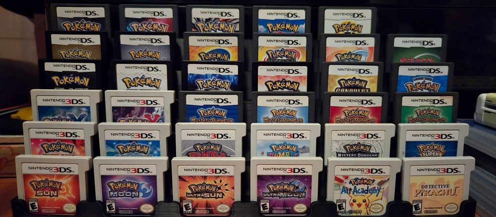 ALL the pokemon ds and 3ds cartridges in a neat lil display!!!! there's one empty slot in the stand though...