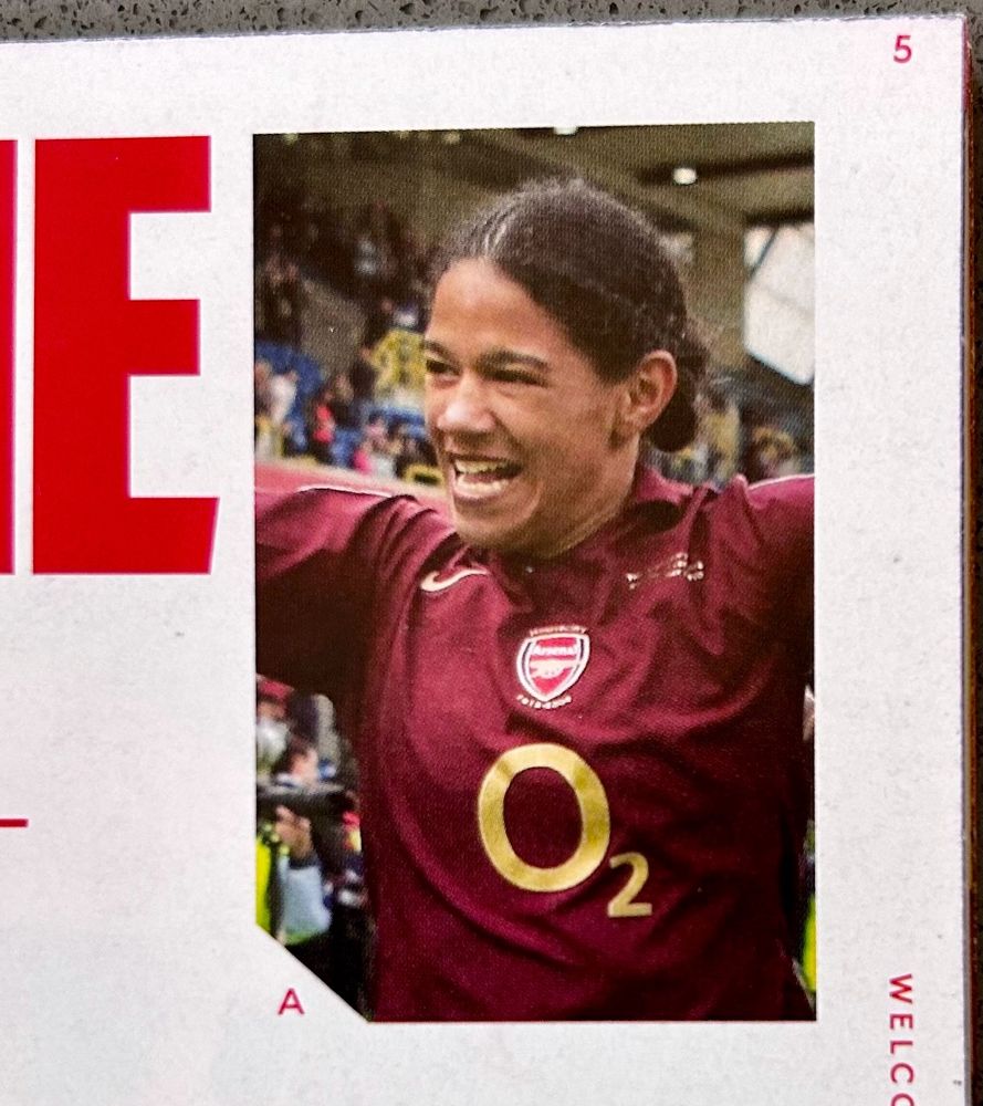 Head and upper body of the amazing Mary Phillip in the Arsenal burgundy kit celebrating in front of a supportive crowd 