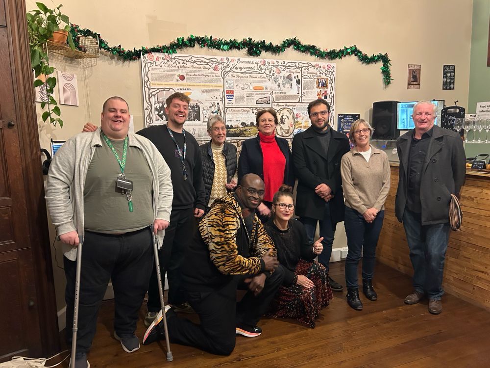A group of researchers stand in front of a historical exhibition they made about the lives of ordinary people connected to a large mansion in Dulwich