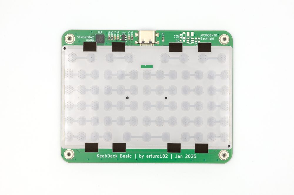 A photo of the KeebDeck Basic with the top cover removed, some of the components are visible, and some are missing. The dome sheet is also visible.