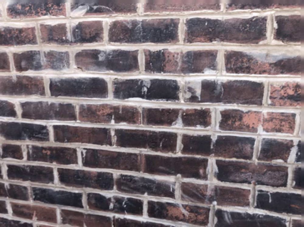 a close up of a brick wall with a few white bricks