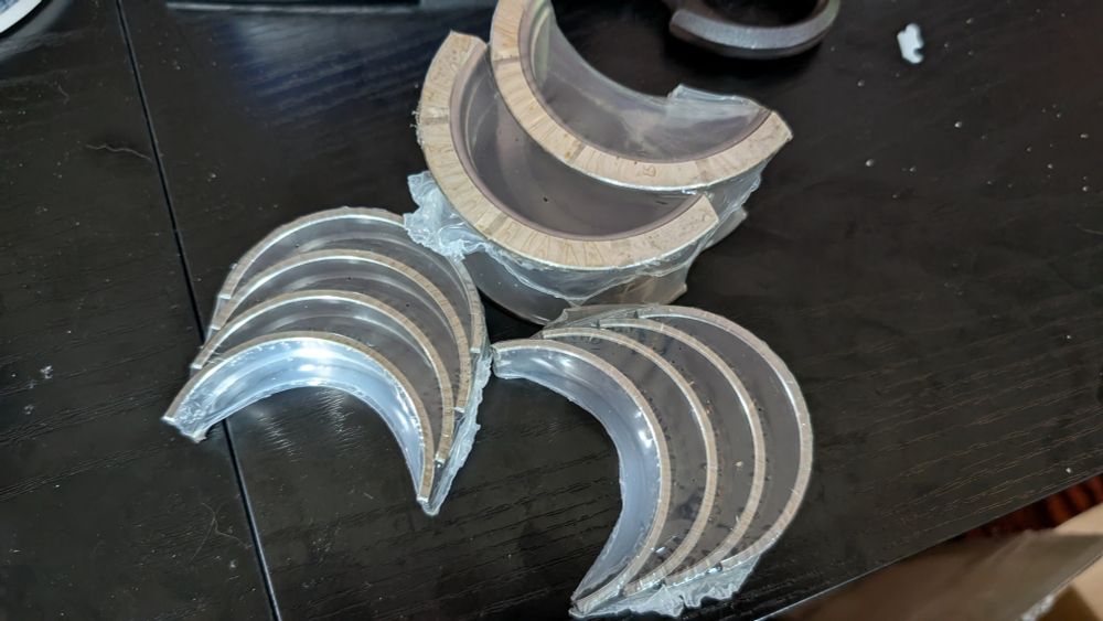 Main engine bearings, shrink-wrapped and sitting on a table.