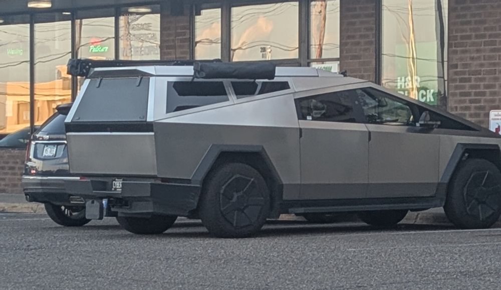 A cyber truck with a bizarre matching stainless steel topper 