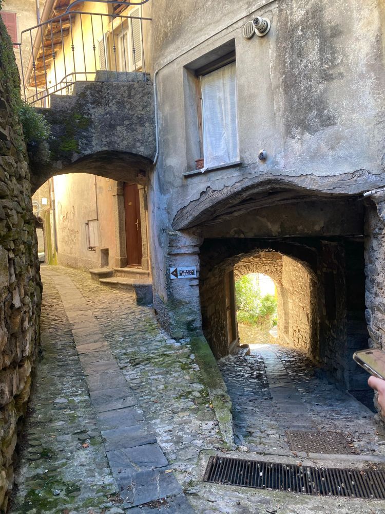 Veien deler seg og går under et hus (til høyre) under en trapp (til venstre)