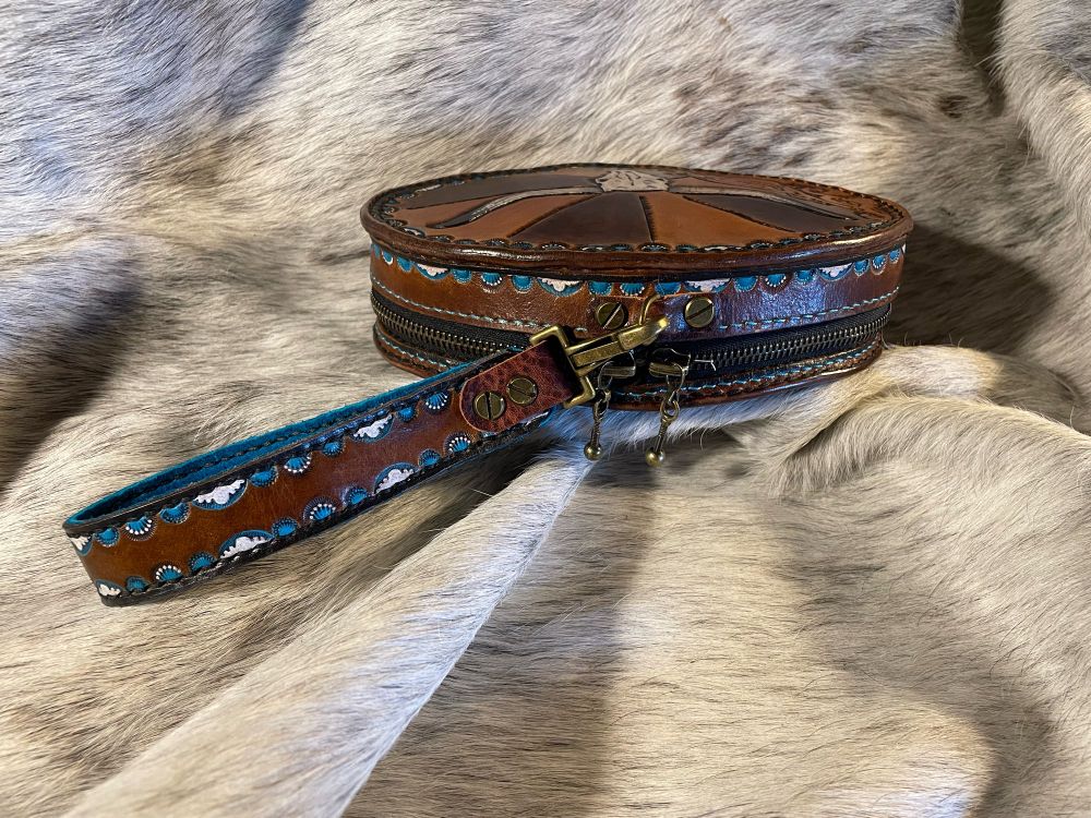 Top view of wristlet showing the white and turquoise painted and stamped border on brown back ground.