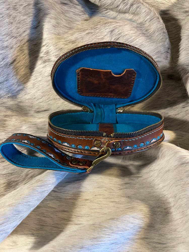 Interior shot of wristlet showing the turquoise deerskin suede lined interior with a card pocket.