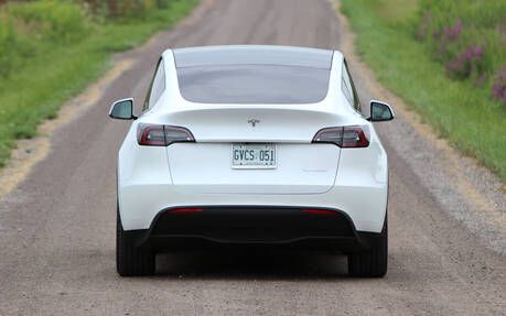 Picture of a white Tesla car from behind that resembles an unpleasant piece of clothing.