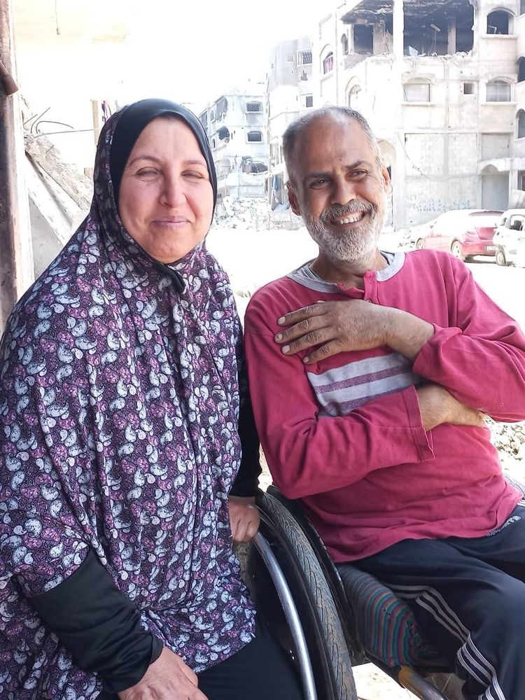 Boshra on the left sitting next to Mohammad, who is in a wheelchair. Both are smiling 