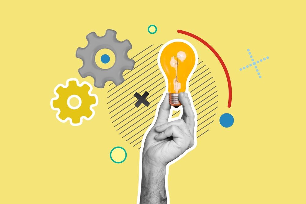 Black and white hand holds a colorful lightbulb against a light yellow background and images of cogs and momentum 