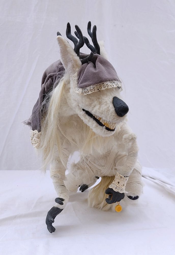 doll of a boss monster from game bloodborne. she's a woman turned into large white fluffy wolf like creature with antlers. torn durning transformation her coat hangs on her head like a hood.