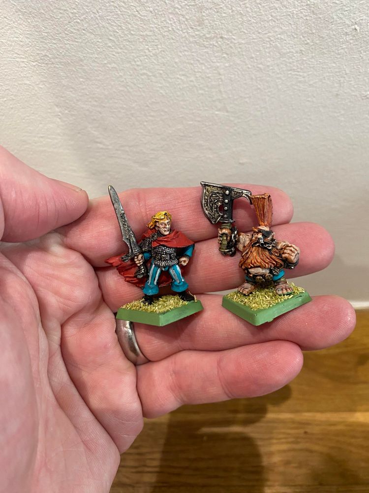 Gotrek and Felix miniatures in a big paw. 