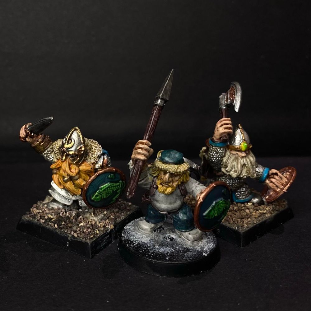 Three Dwarf Treasure Hunters at various stages of completion. L-R Noble with a sword and shield, Beardling with a spear and shield, warrior with an axe. 
