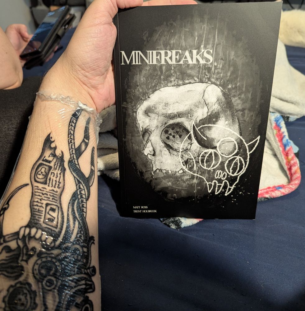My hand holding a copy of Minifreaks by Matt Ross and Trent Holbrook.