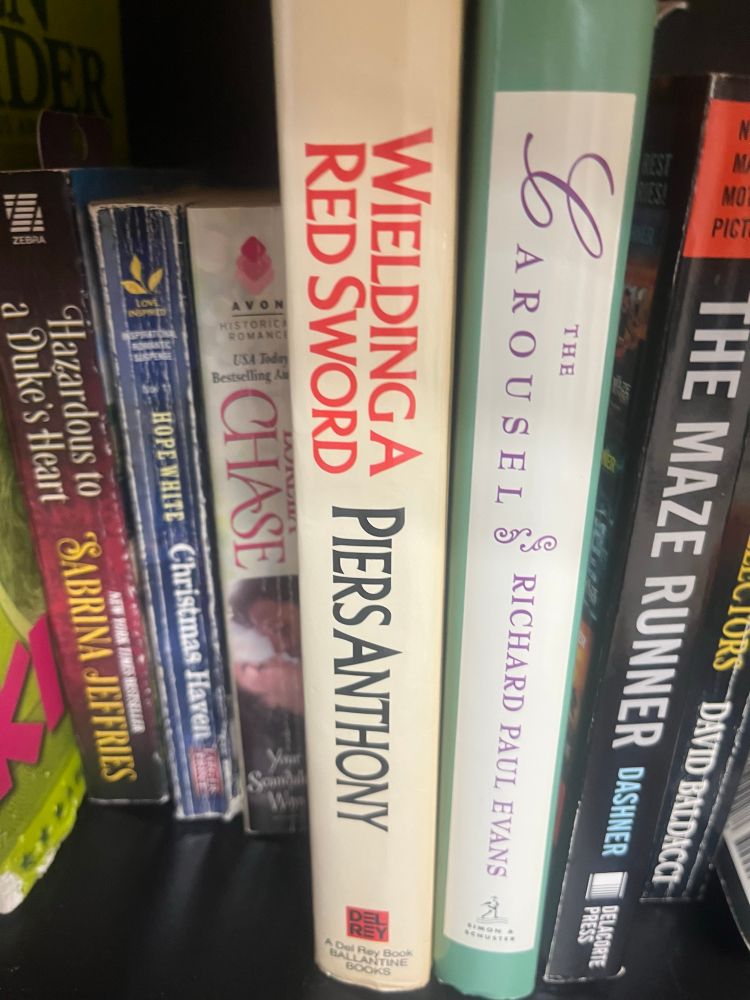 a shelf on my local ymca’s free library, prominently displaying “Wielding a Red Sword” by piers anthony. I’ve never read his work, but per the podcast “On a Pale Microphone”, it is complete dogshit 