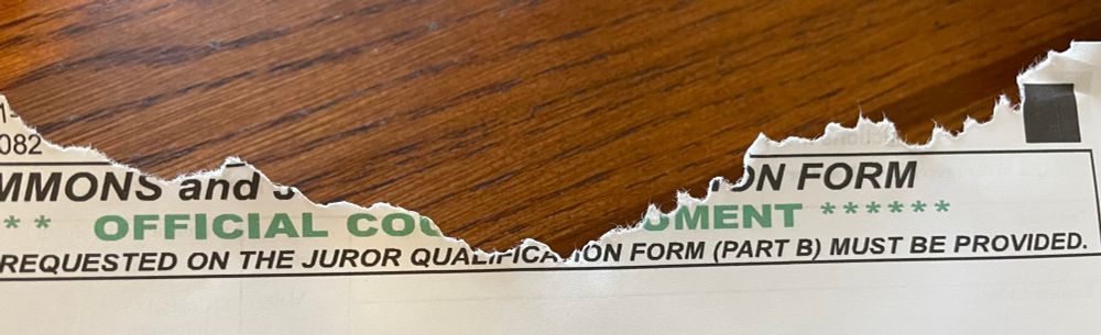 The top of a jury duty summons that has been chewed up